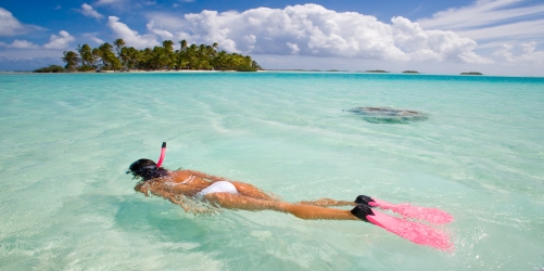 woman free diving in beautiful blue lagoon